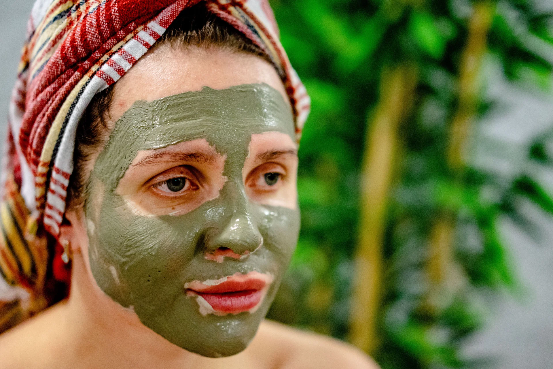 Kobieta relaksuje się w spa, ciesząc się odmładzającą maseczką błotną na twarzy.